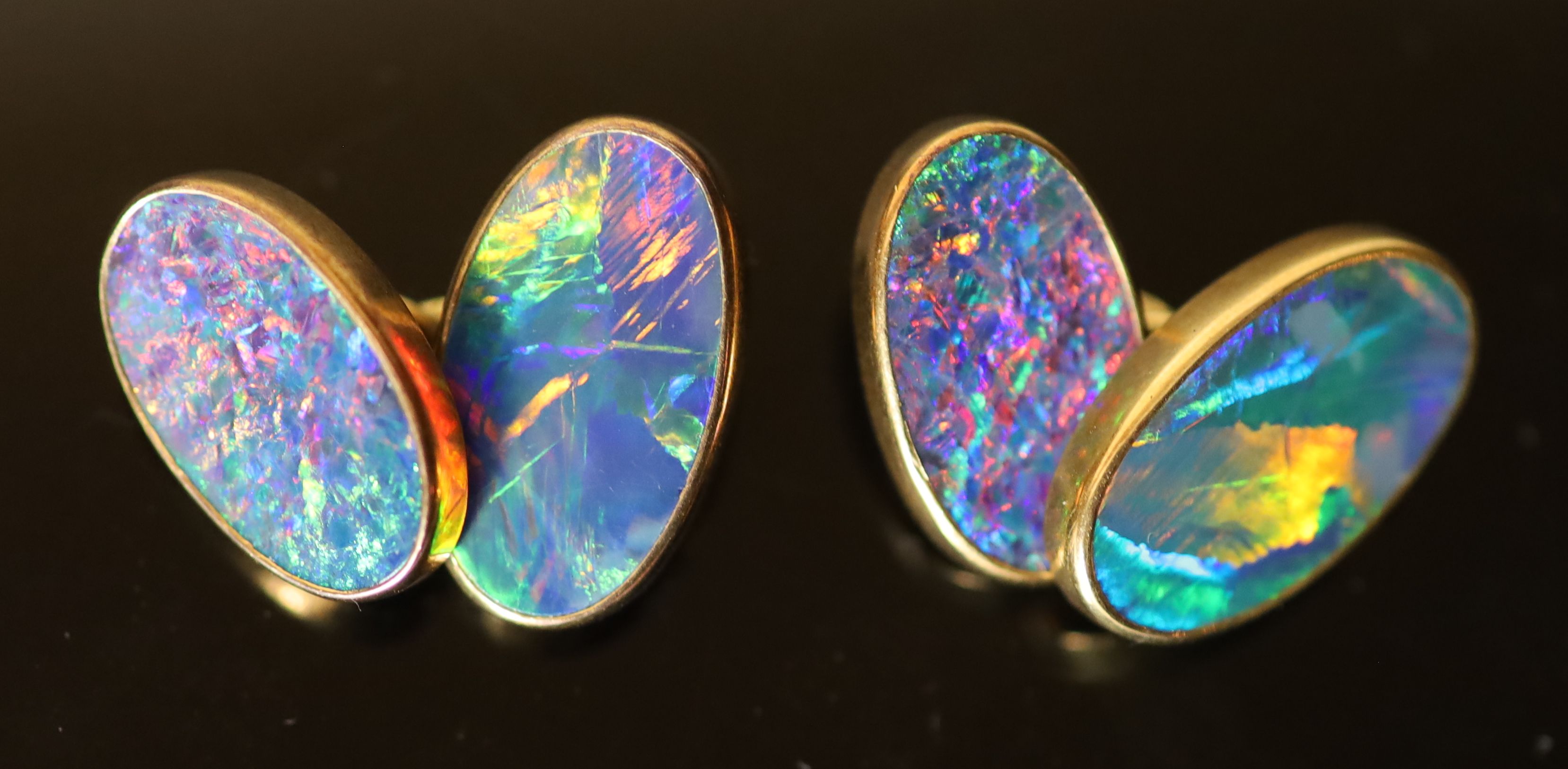 A pair of 18ct gold and black opal set oval cufflinks,